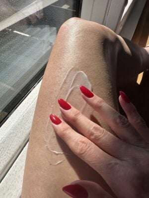 applying exfoliating creme to leg